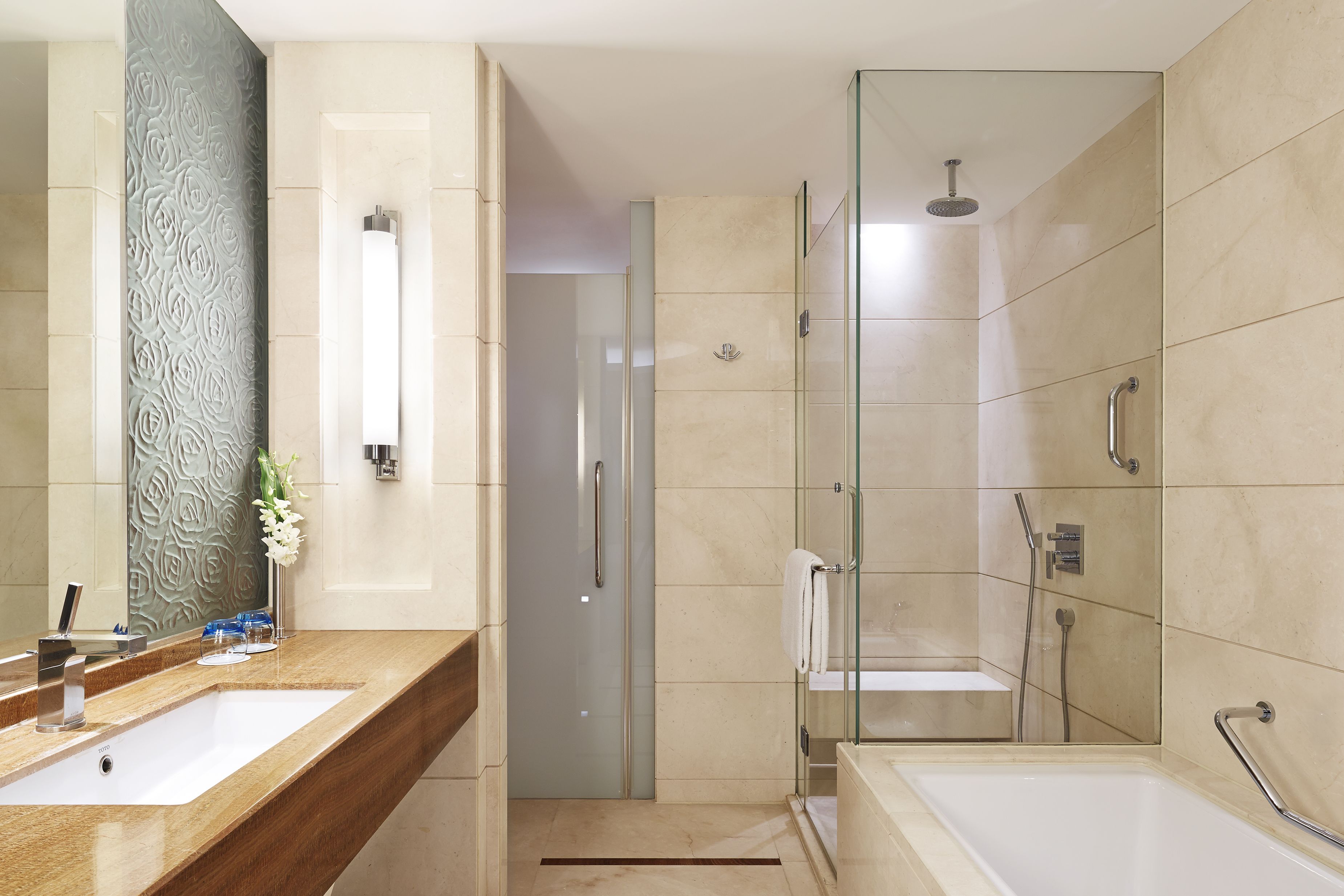 A modern bathroom with a large mirror, a sink, a shower, and a bathtub.
