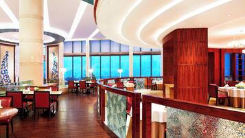 A spacious restaurant with high ceilings, large windows, and a wooden interior.