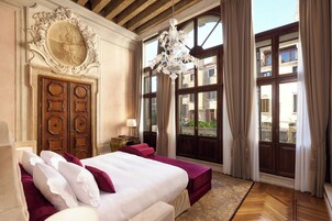 Un dormitorio con una cama grande, un armario de madera y un candelabro.