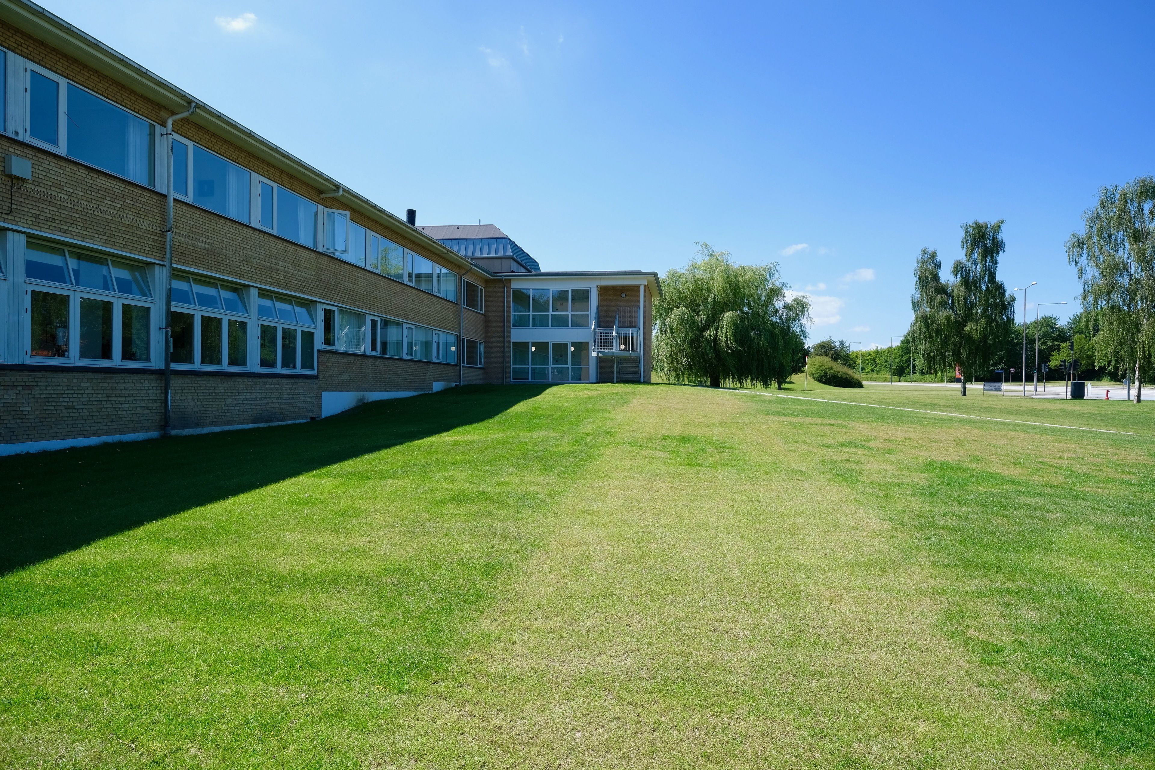 A building with multiple windows and a grassy courtyard.