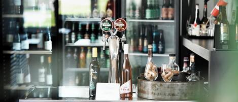 A bar counter with a selection of bottles and a tap labeled "Royal Biodogsk".