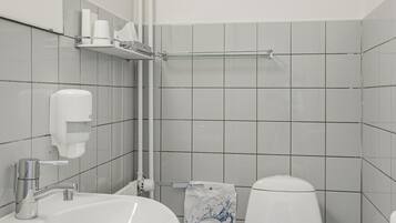 A bathroom with a white sink, toilet, and a towel hanging on the wall.