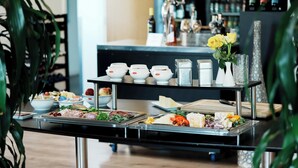 Una mesa de buffet con distintos alimentos y salsas.