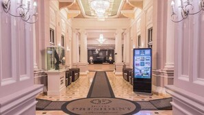 A hotel lobby with a chandelier, a reception desk, and a digital information kiosk. - Hotel President Budapest, Affiliated by Meliá (Budapest)
