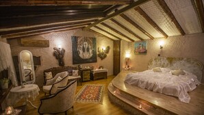Une chambre à coucher chaleureuse avec un lit aux courbes douces, un plafond en bois et un mur au style rustique.