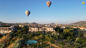 Une ville qui se distingue par un bâtiment remarquable, doté d’une grande tour, et entourée de verdure sous un ciel dégagé.