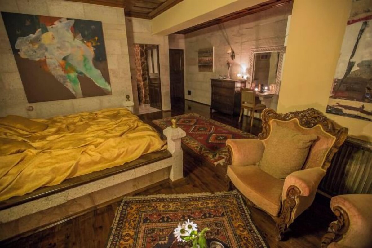 Une pièce comprenant un lit, une chaise, un bureau et un tableau accroché au mur.