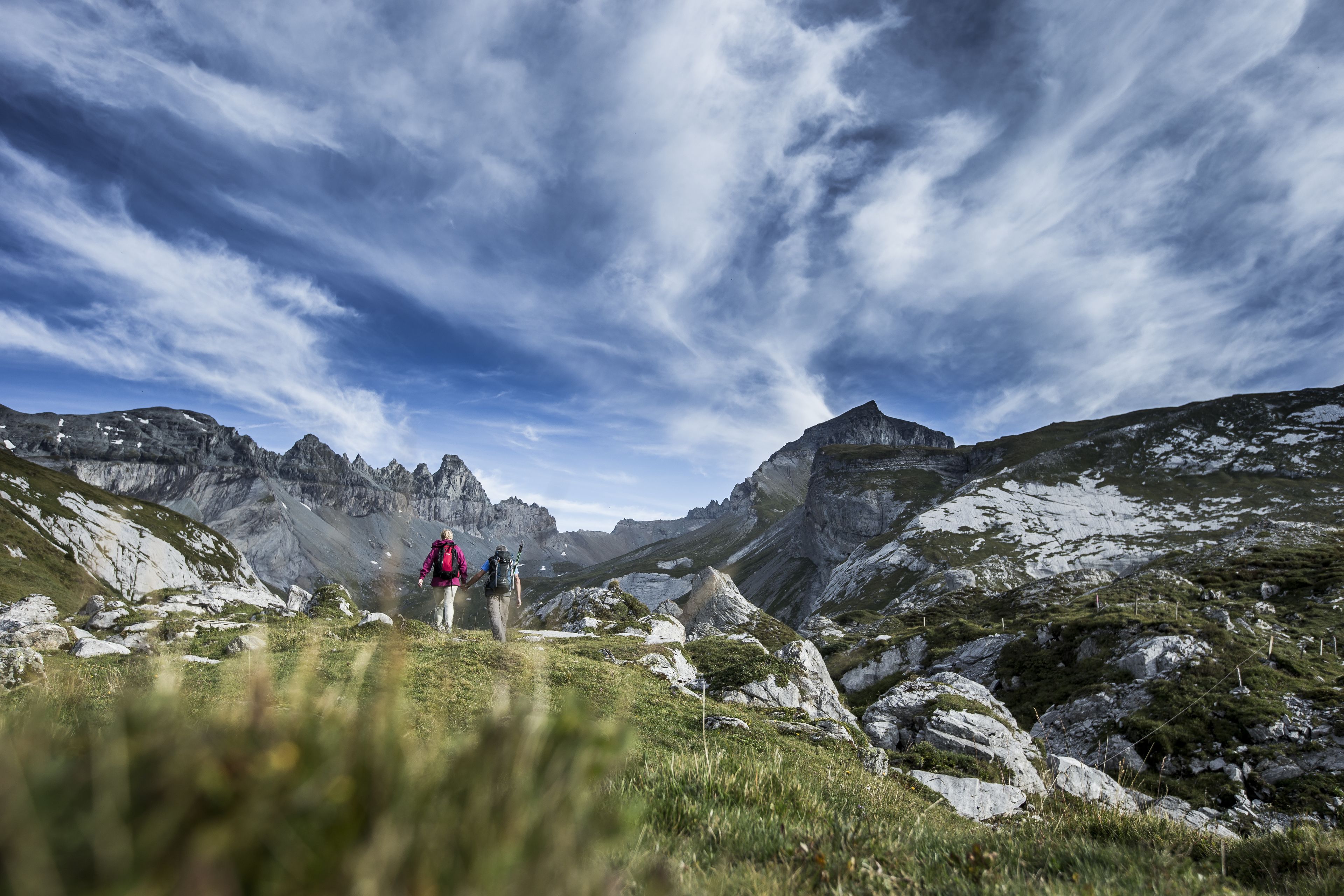 Eine gebirgige Landschaft, im Vordergrund ein Wanderer.