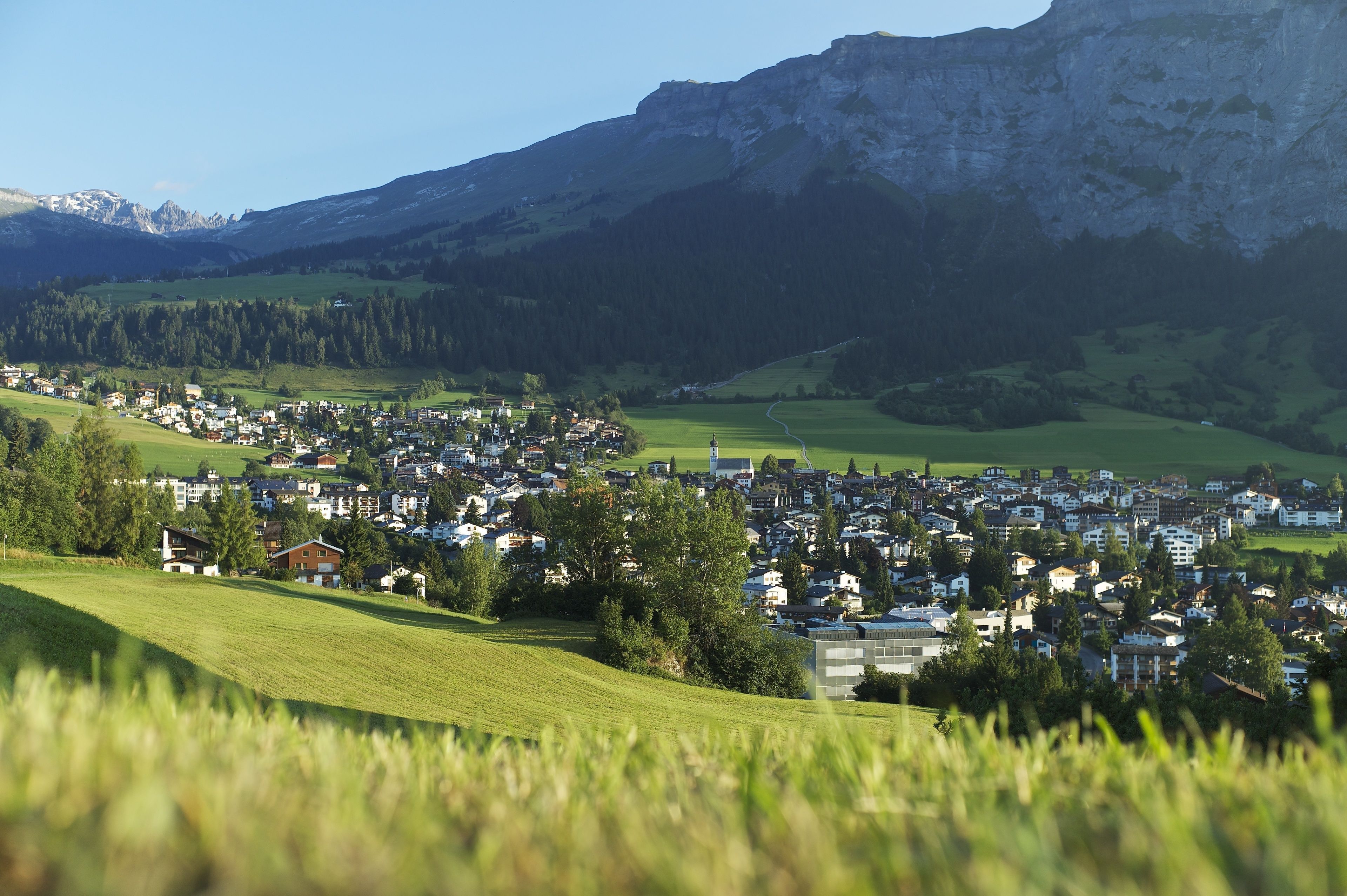 A town nestled in a valley with a prominent mountain in the background.