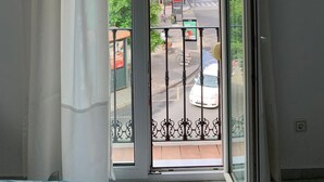 A balcony with a view of a street and buildings. - Hotel Doña Blanca (Seville)