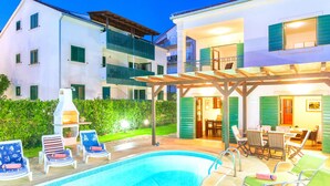 A pool area with lounge chairs and a barbecue grill. - Villa Cvita (Hvar)