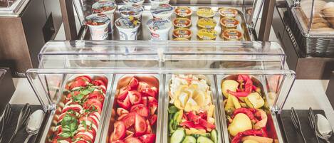 A buffet with various food items including yogurt, salads, and vegetables.