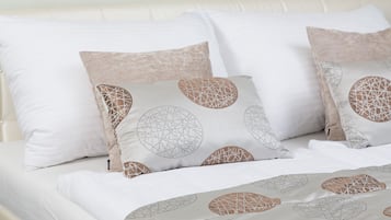 Una cama con ropa de cama y almohadas con diseños geométricos.