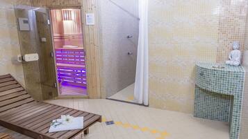 Uma sala de sauna com um banco de madeira, uma pequena estátua e um revestimento de azulejos.