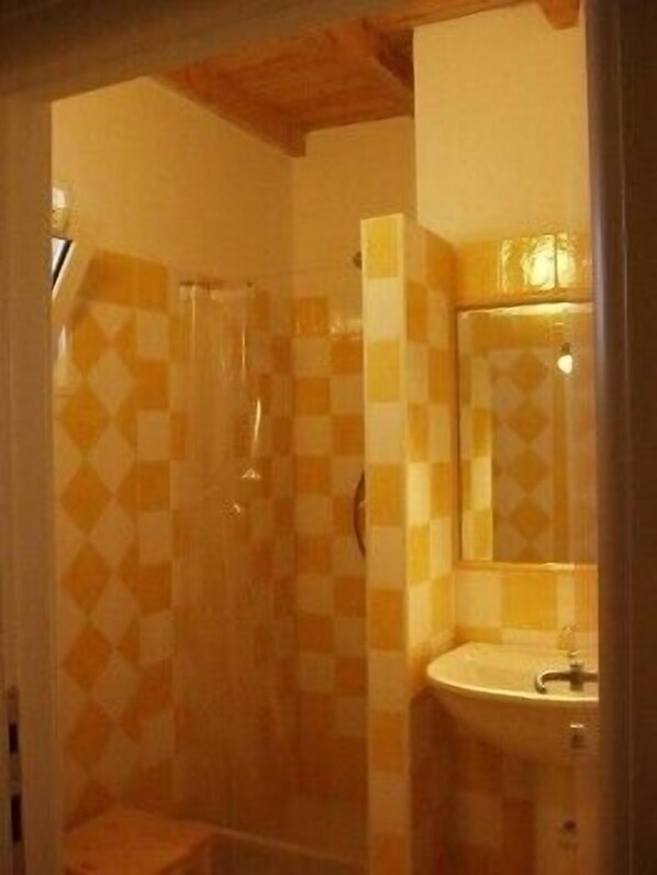 A bathroom with a checkered tile pattern, a sink, and a shower.