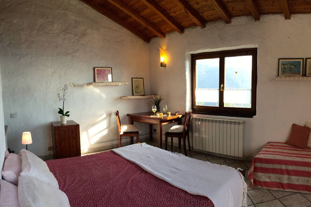 Une chambre confortable avec deux lits, un bureau en bois, une chaise et une fenêtre donnant sur un beau paysage.