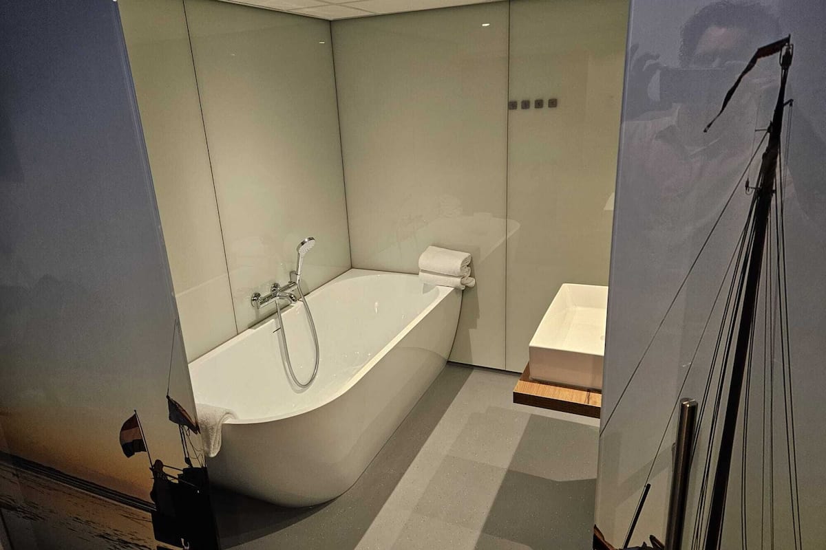 Et moderne badeværelse med et fristående badekar, toilet og bruser.