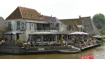 A riverside hotel with outdoor seating, a restaurant, and a boat dock.