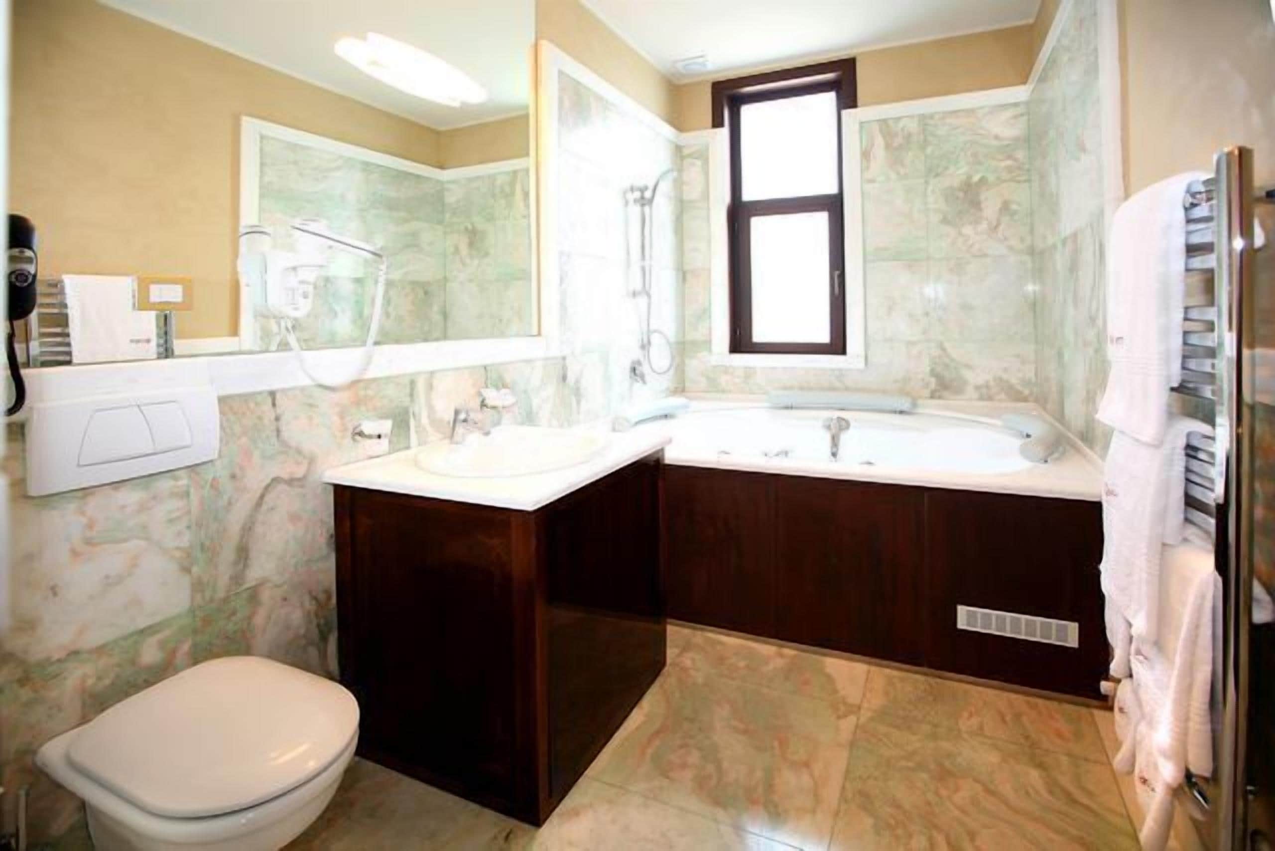 A bathroom with a toilet, a sink, a bathtub, and a shower.
