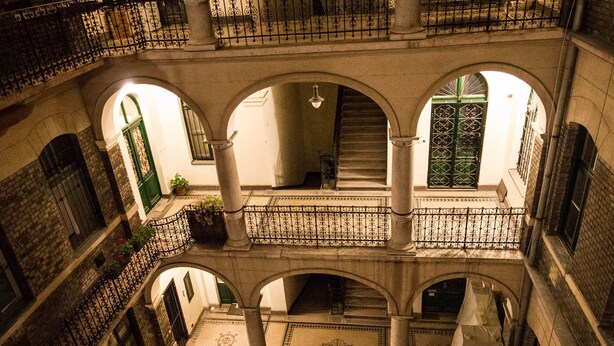 A multi-level building with arched balconies, a central staircase, and a series of windows. - RingAvenue Apartments (Budapest)