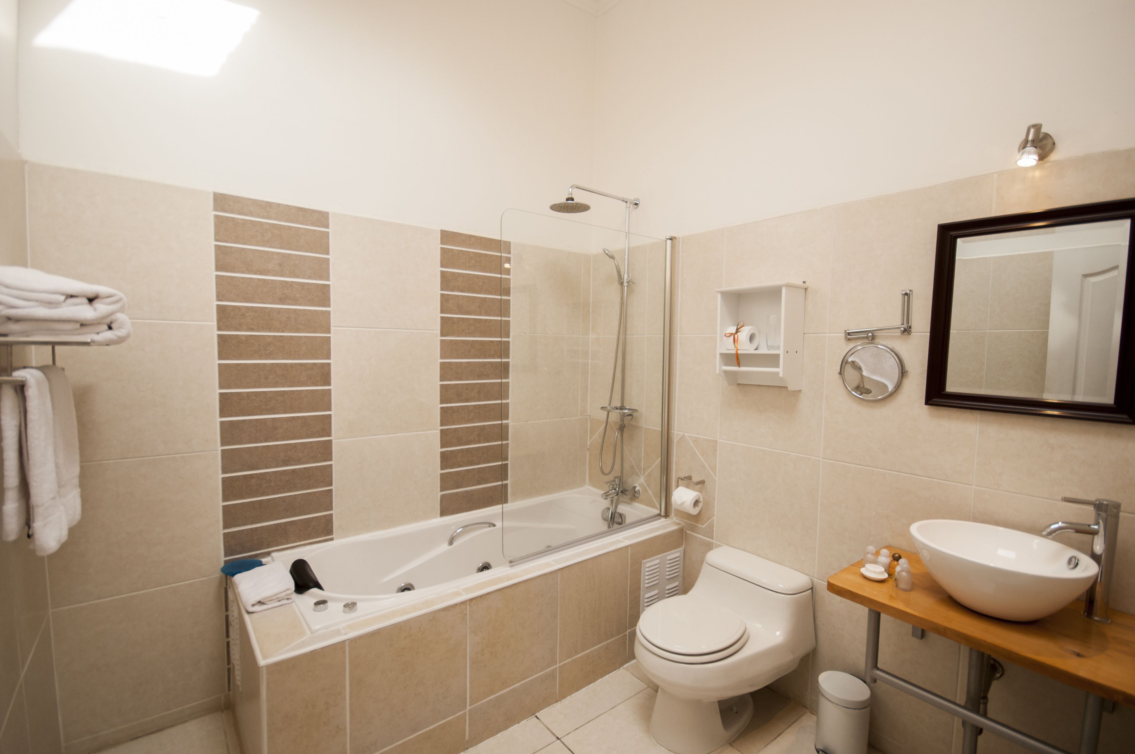 Een moderne badkamer met een bad, toilet en wastafel.