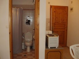 Un baño pequeño con inodoro, lavabo y puerta de madera.