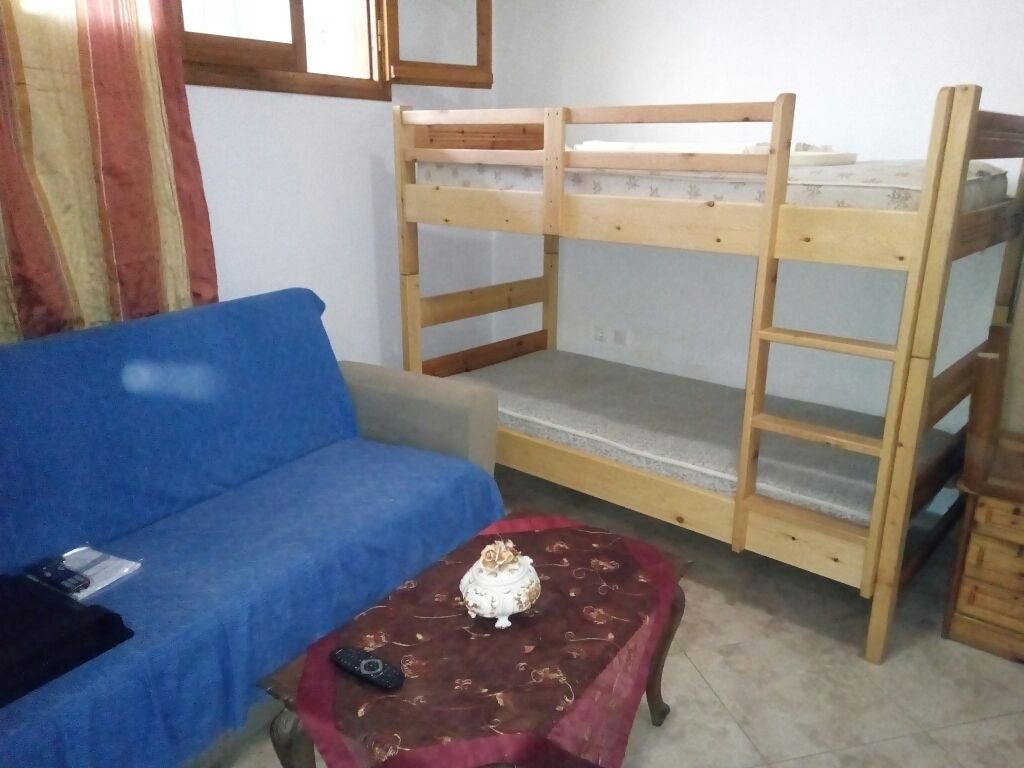 A bunk bed with a blue sofa and a small table with a cake.