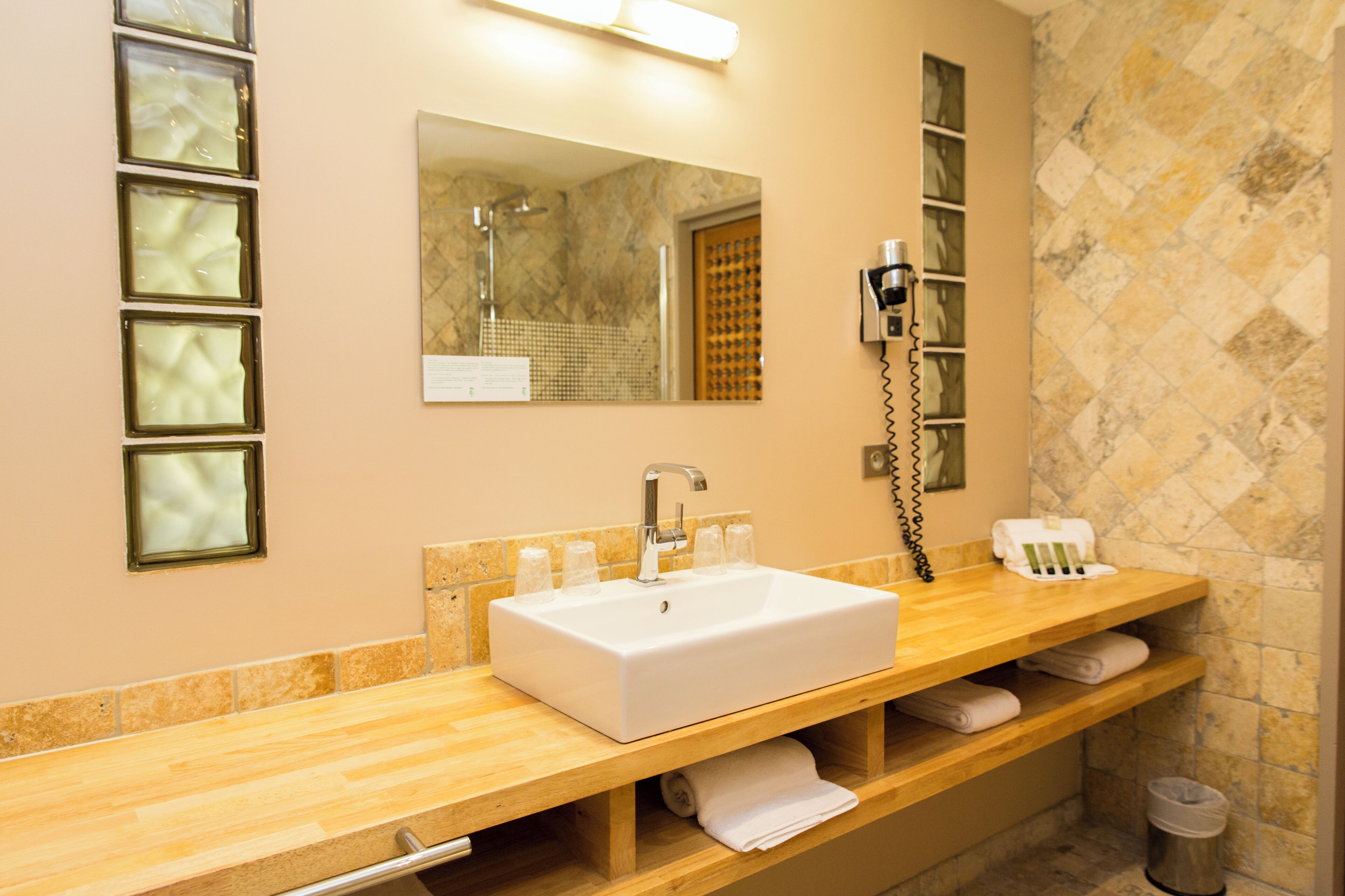 A bathroom with a white sink, a mirror, and a towel rack.