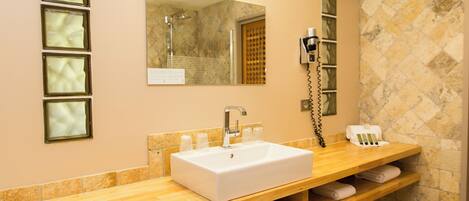 A bathroom with a white sink, a mirror, and a towel rack.