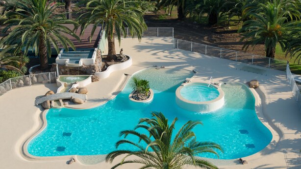 A large, multi-level swimming pool with palm trees and lounge chairs. - Campo Dell'Oro (Ajaccio)