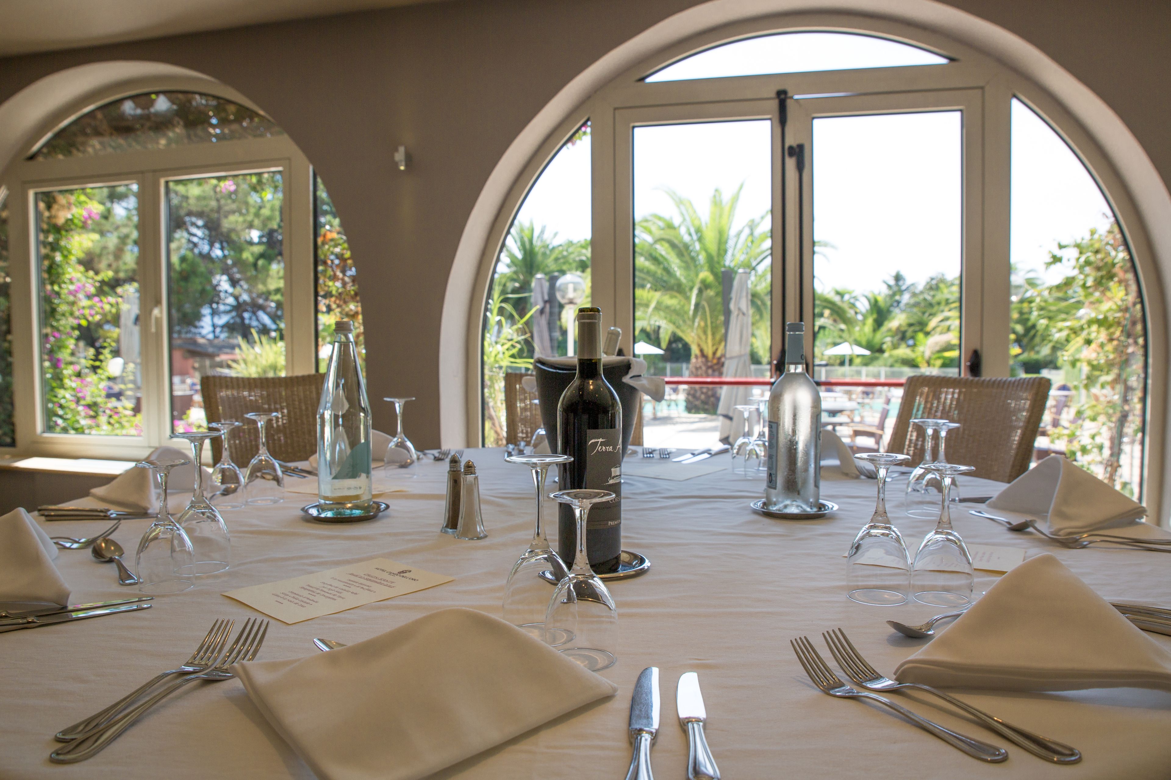 Una mesa dispuesta para una comida, con copas de vino, botellas y cubiertos.