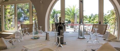 Una mesa dispuesta para una comida, con copas de vino, botellas y cubiertos.