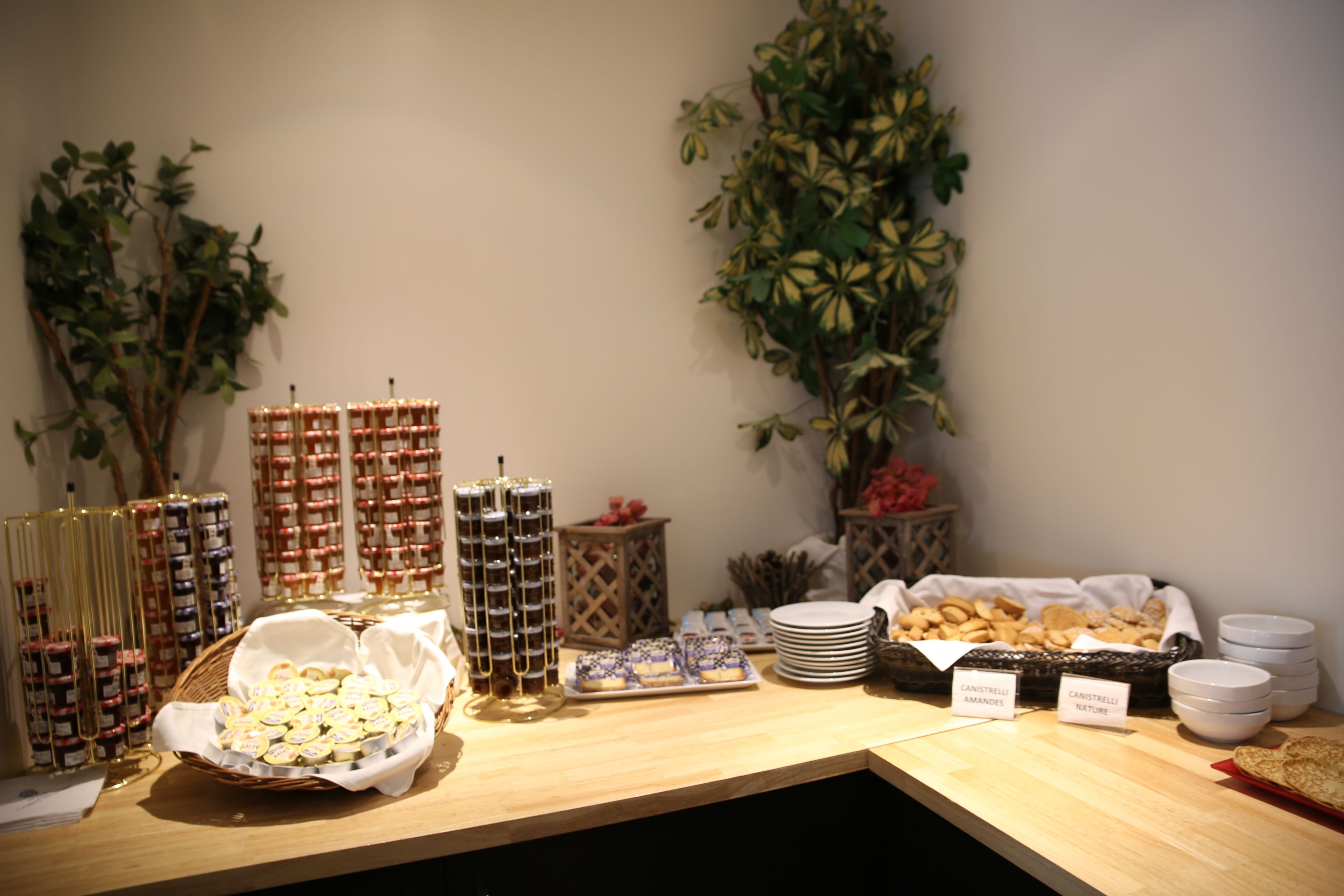 A buffet table with various food items and condiments.