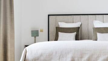 Un dormitorio moderno con cama, mesita de noche y lámpara.