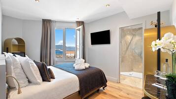 Une chambre d’hôtel moderne dotée d’un grand lit, d’une télévision, d’une douche et offrant une vue sur l’extérieur.