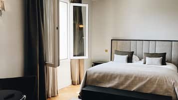 Un dormitorio moderno con una cama grande, un escritorio y una ventana con cortinas.
