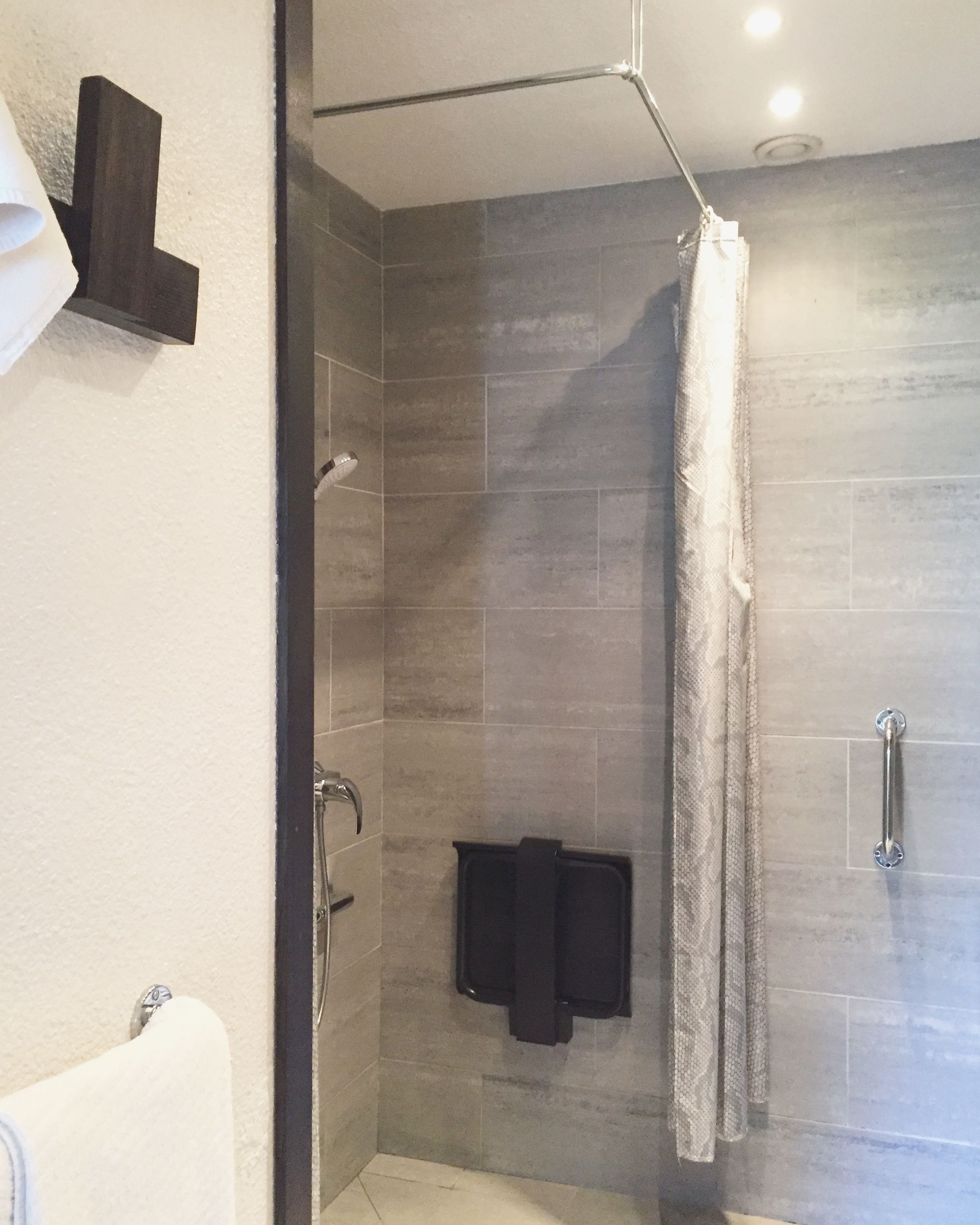 Une salle de bain moderne équipée d’une douche, d’un porte-serviettes et d’un distributeur de serviettes.