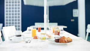 Una mesa de desayuno con una taza de café, un croissant, huevos y jugo.