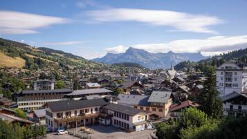 A town with traditional architecture, a central square, and a mountain backdrop.
