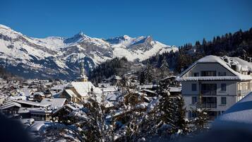 A snow-covered mountain village with traditional buildings and a prominent church.