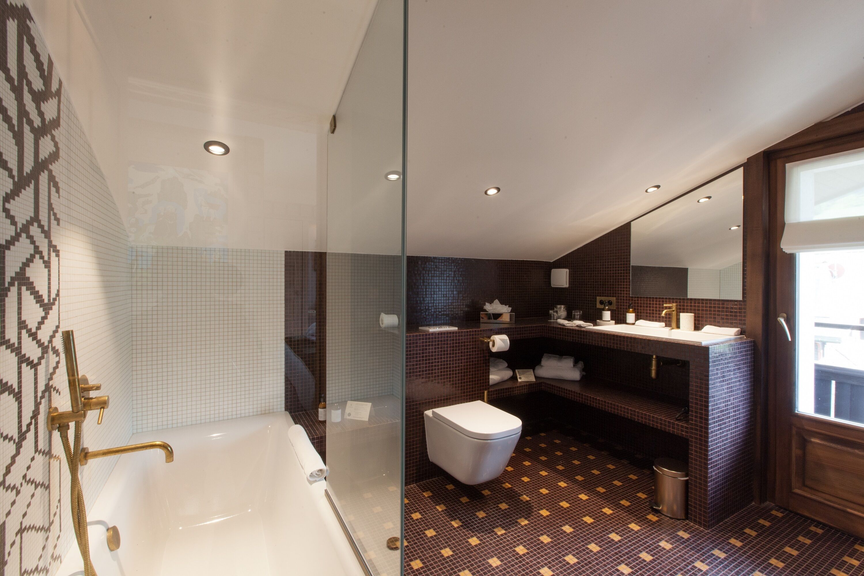 A modern bathroom with a glass-enclosed shower, a bathtub, a toilet, and a vanity with a mirror.