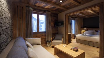 Una habitación acogedora estilo cabaña de madera con un sofá, un sillón y una cama.