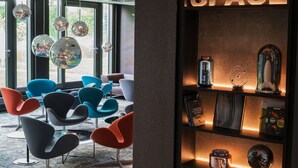 Un interior moderno con un letrero que dice 'SPACE', sillas contemporáneas y una estantería con diversos objetos.
