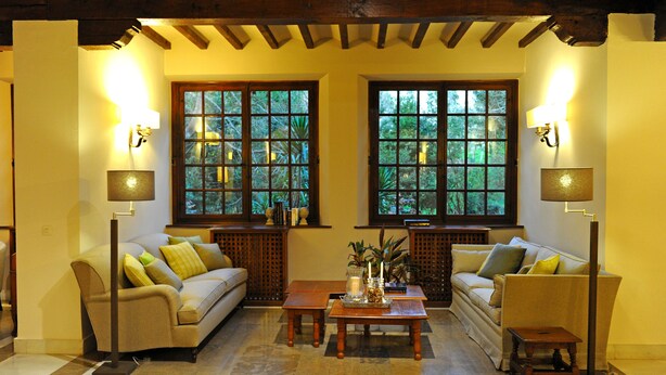 A cozy living room with two sofas, a coffee table, and two floor lamps. - Parador de Santillana Altamira (Santillana del Mar)