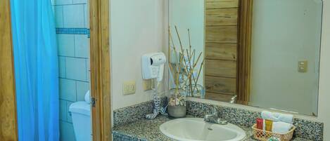 A bathroom with a white sink, a mirror, and a shower curtain.