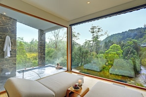 A spa room with a large window overlooking a forested area and a hot tub. - Peppers Cradle Mountain Lodge (Cradle Mountain)