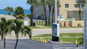 A parking lot with a sign for the Atlantic Inn. - Atlantic Inn (Indialantic)