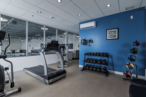 Ein Fitnessstudio mit Laufbändern, Gewichten und Trainingsbällen.