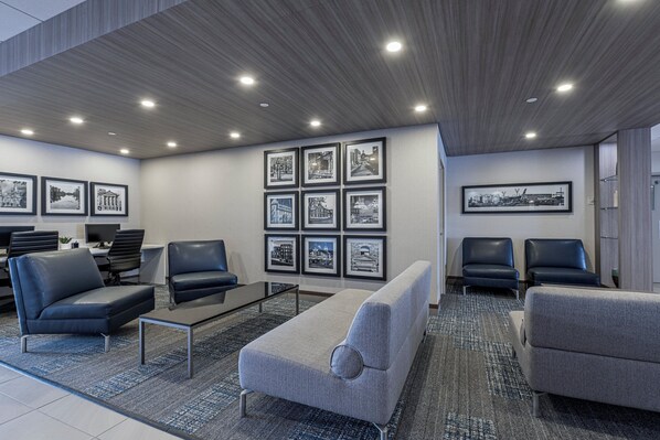 A modern waiting area with a sofa, chairs, a coffee table, and framed pictures on the wall. - Holiday Inn Express Hotel Saint - Hyacinthe by IHG (Saint Hyacinthe)