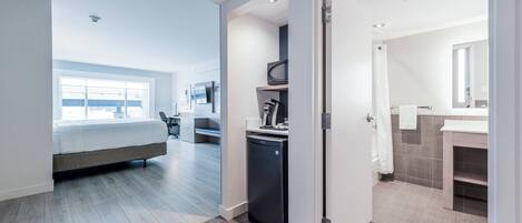 Habitación de hotel moderna con cama, escritorio y baño.